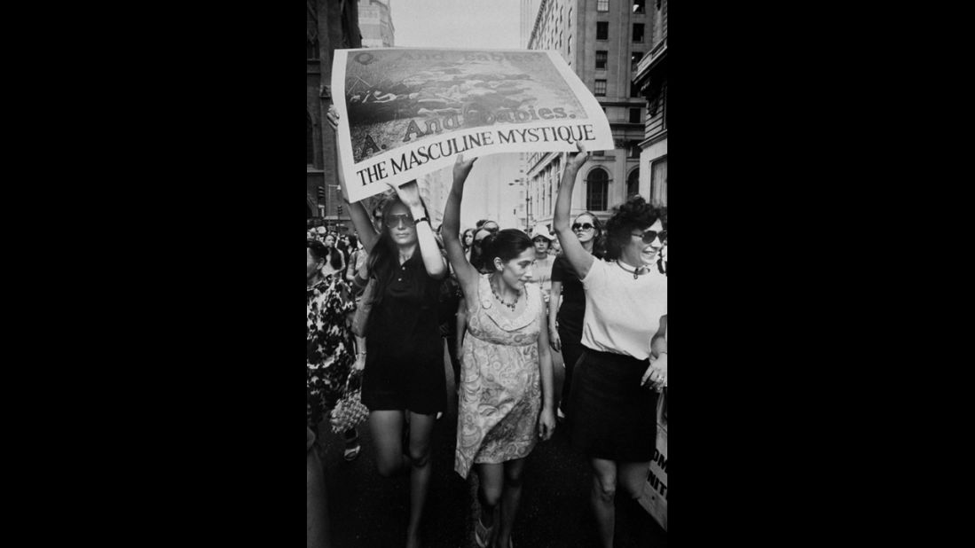 Steinem, left, helps hold up an image of the My Lai Massacre during a 1970 march down New York's Fifth Avenue.