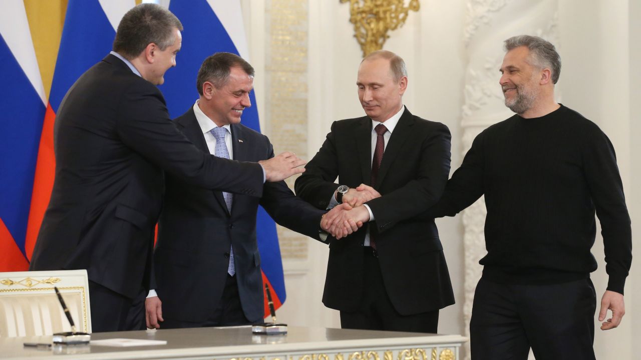 From left, Crimean Prime Minister Sergey Aksyonov; Vladimir Konstantinov, speaker of the Crimean parliament; Russian President Vladimir Putin; and Alexei Chaly, the new de facto mayor of Sevastopol, join hands in Moscow on March 18 after signing a treaty to make Crimea part of Russia.