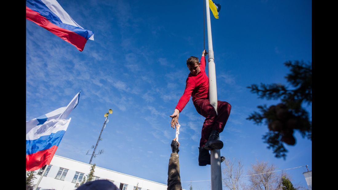A member of pro-Russian forces takes down a Ukrainian flag at the Ukrainian navy headquarters in Sevastopol on March 19. 