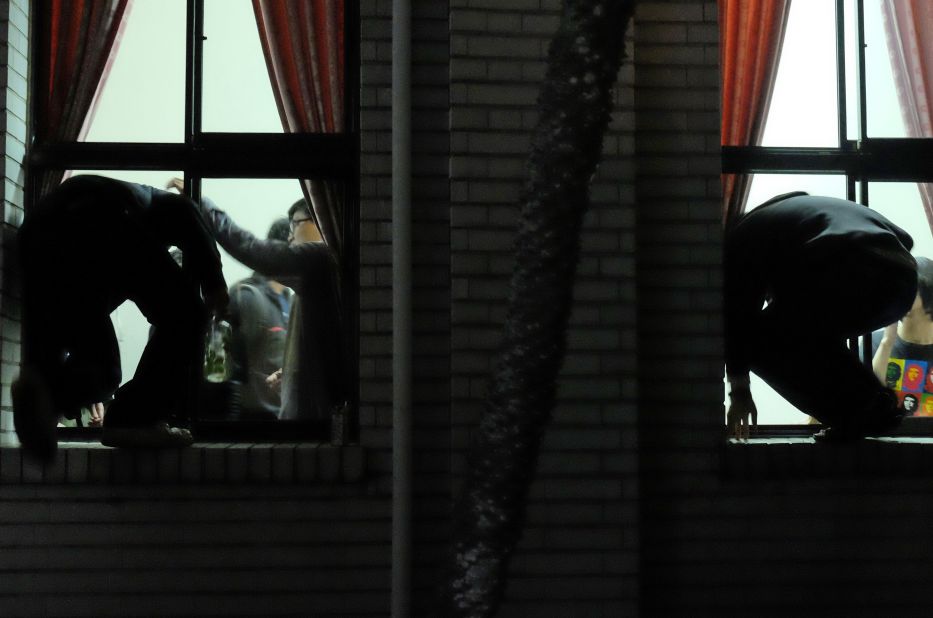 Protesters climb through the windows of the Legislature on March 19.