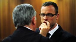 Oscar Pistorius speaks with his lawyer on the thirteenth day of his trial for the murder of his girlfriend Reeva Steenkamp.