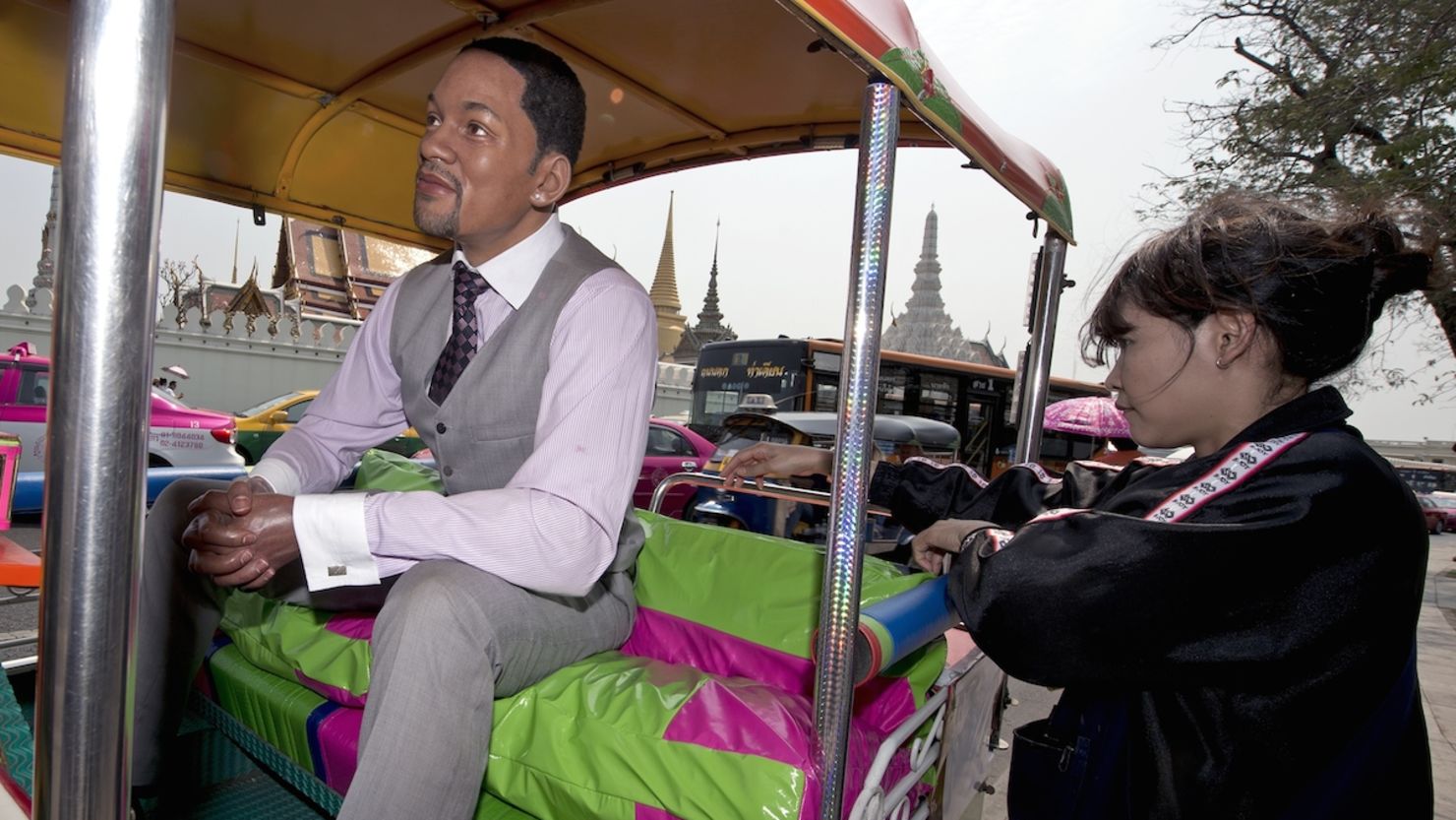 A woman checks out a wax sculpture of U.S. actor Will Smith sitting in a tuk-tuk outside Bangkok's Temple of the Emerald Buddha. Madame Tussauds Bangkok set up the sculptures to promote the museum to tourists in the wake of the political crisis. 