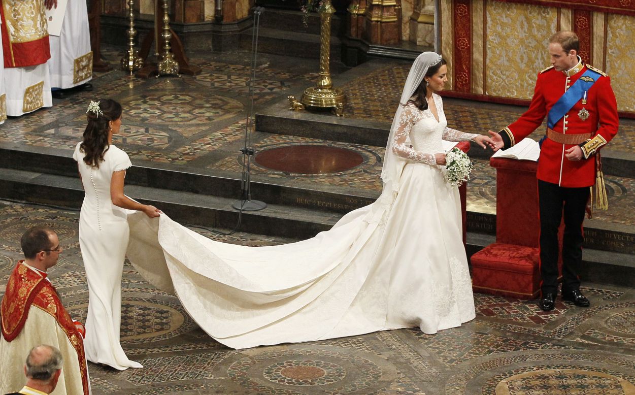 Britain's Prince William and his wife Kate, Duchess of Cambridge, accompanied by her maid of honor Pippa Middleton leave after the wedding service in Westminster Abbey in central London on April 29, 2011. 