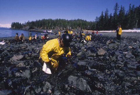 A Valdez worker wipes oil off the rocks on the shoreline.
