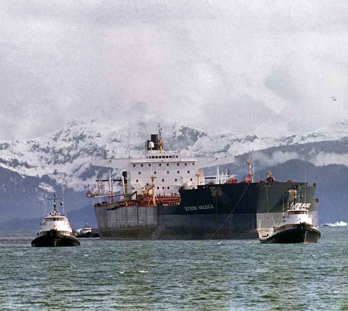 Tugboats tow the Exxon Valdez off Bligh Reef to a harbor for repair and salvage efforts, two weeks after the beginning of the oil disaster. The tanker changed names and owners several times, and was bought in 2012 by an Indian company, which scraps ships for steel and spare parts.