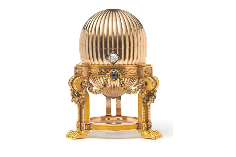 The 8.2-centimeter (3.2-inch) Faberge egg is on an elaborate gold stand supported by lion paw feet. Three sapphires suspend golden garlands around it, and a diamond acts as an opening mechanism.