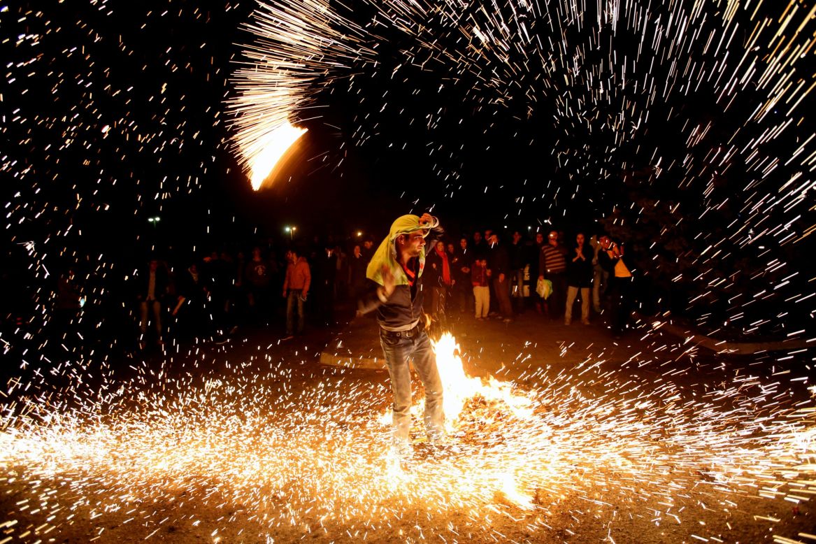 MARCH 20 - TEHRAN, IRAN: An Iranian man lights fireworks during a celebration, known as "Chaharshanbe Soori," held on  the eve of the last Wednesday before spring, in Pardisan Park. The first day of spring is known as Nowruz -- the Persian new year.
