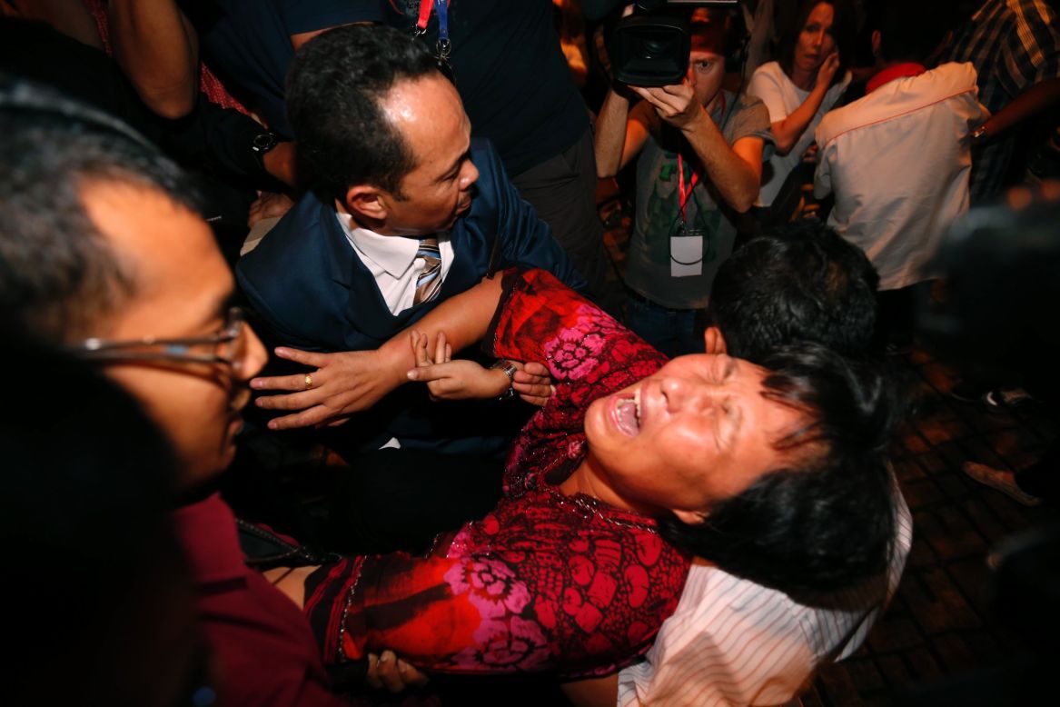 A distraught relative of a passenger on the missing <a href="http://www.cnn.com/2014/03/07/asia/gallery/malaysia-airliner/index.html">Malaysia Airlines Flight 370</a> is carried out by security officials before a press conference in Sepang, Malaysia, on Wednesday, March 19. The plane disappeared during a March 8 flight from Kuala Lumpur to Beijing.