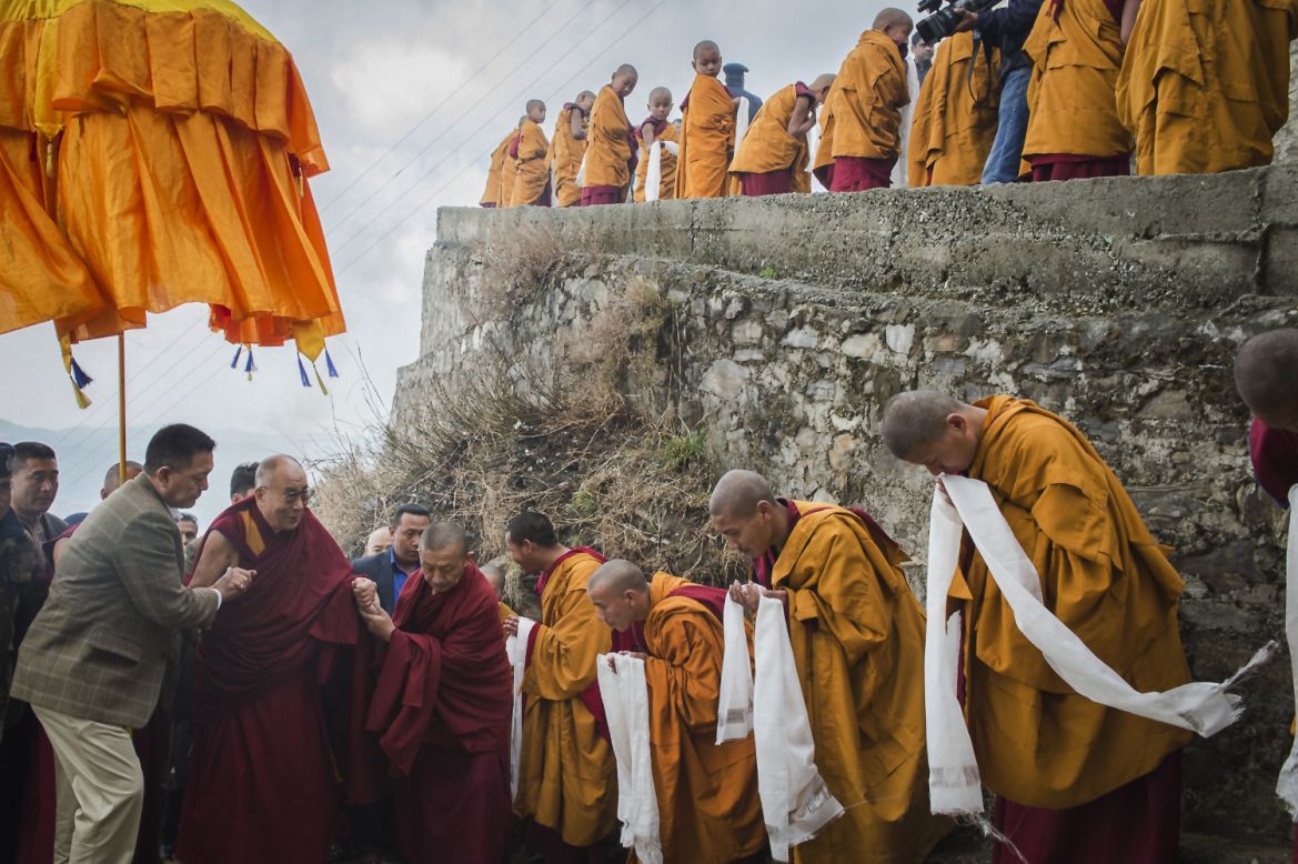 Tibetan Buddhist monks holding ceremonial scarfs stand in a line to welcome their spiritual leader the Dalai Lama as he arrives at the Jhonang Takten Phuntsok Choeling monastery in Shimla, India, on Tuesday, March 18.