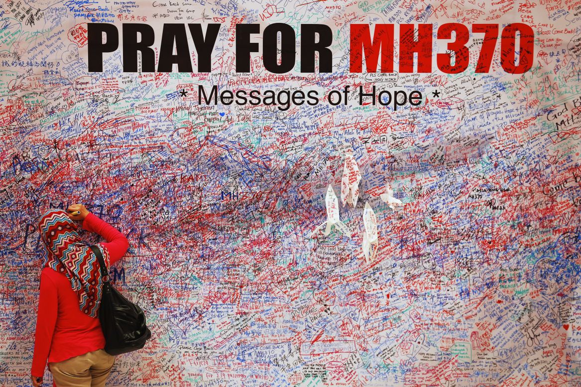 A woman in Kuala Lumpur, Malaysia, leaves a message for the passengers of Malaysia Airlines Flight 370 on Sunday, March 16.