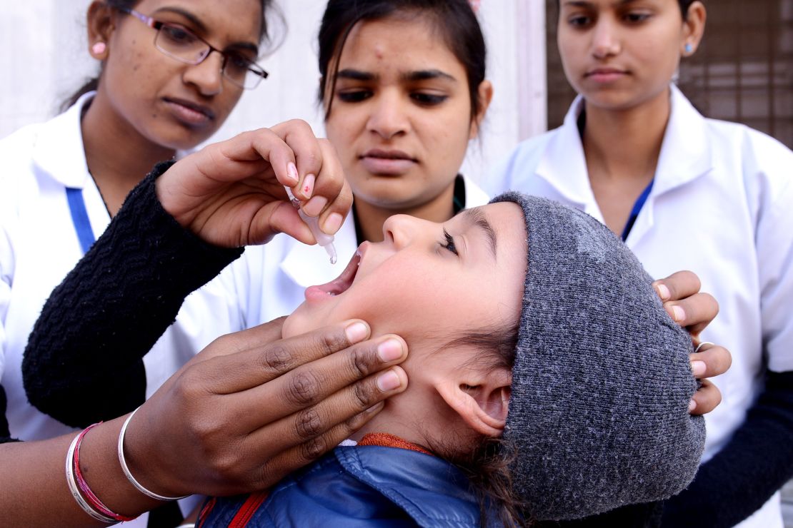 An child receives polio vaccination drops from a medical volunteer in Amritsar, India, on January 19.