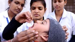 An child receives polio vaccination drops from a medical volunteer in Amritsar, India, on January 19.