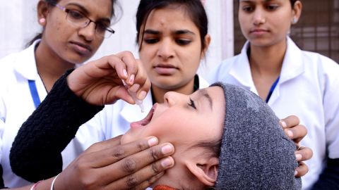 A child receives a polio vaccine from a medical volunteer in Amritsar, India.