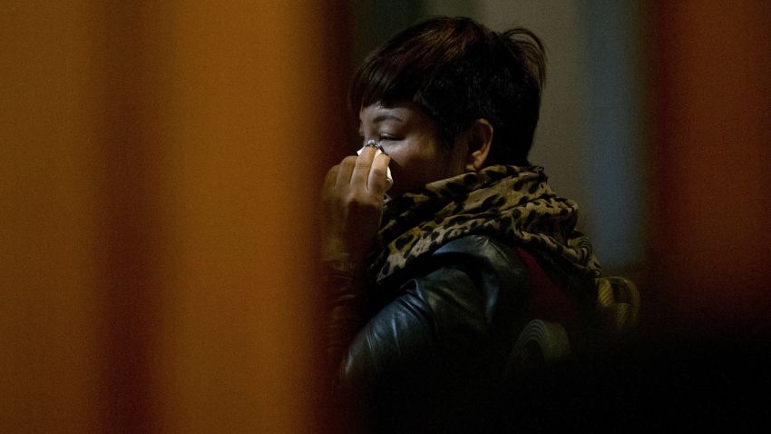 One of the relatives of Chinese passengers aboard missing Malaysia Airlines Flight MH370 wipes her tears as she watches a TV news program about the missing flight after a briefing meeting with Malaysian officials in a hotel ballroom in Beijing, China, Friday, March 21, 2014.