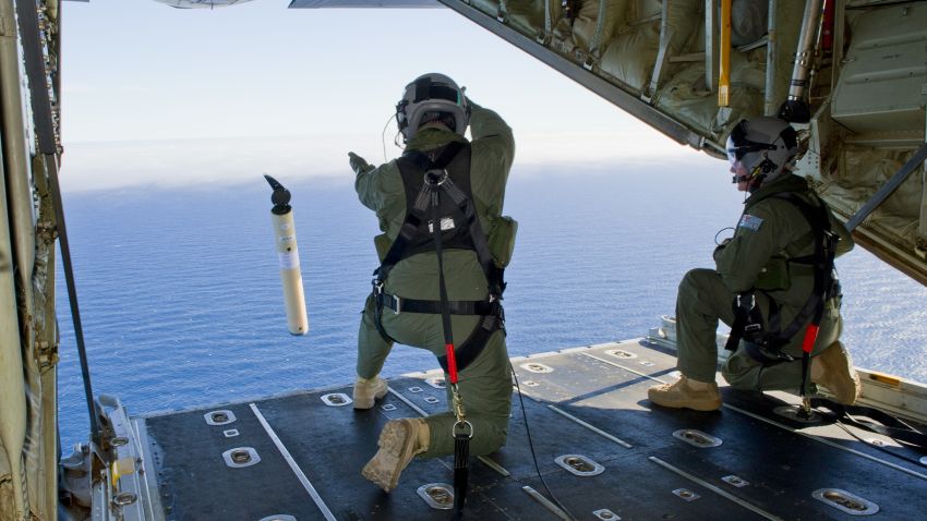 Royal Australian Air Force Loadmasters, Sergeant Adam Roberts (left) and Flight Sergeant John Mancey, launch a Self Locating Data Marker Buoy from a C-130J Hercules aircraft in the southern Indian Ocean as part of the Australian Defence Force's assistance to the search for Malaysia Airlines flight MH370.