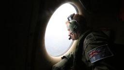 A crew member on a Royal Australian Air Force AP-3C Orion aircraft looks out a window during the Australian Maritime Safety Authority-led search for Malaysia Airlines Flight MH370 in the Southern Indian Ocean on Friday, March 21.