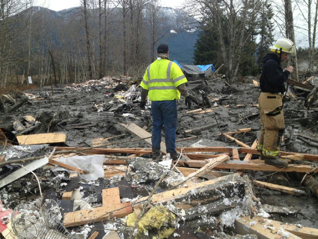 Emergency workers arrive at the scene of the landslide on Saturday, March 22.