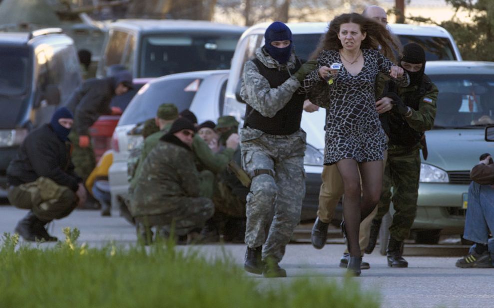 Pro-Russian militia members remove a local resident as Russian troops assault the Belbek air base, outside Sevastopol, on Saturday, March 22. Following its annexation of Crimea, Russian forces have consolidated their control of the region.