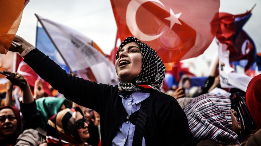 A woman supporting Turkey's Prime Minister cheers and wave Turkish and AK Party (AKP) flag during an election rally in Istanbul on March 23, 2014. Prime Minister Recep Tayyip Erdogan rallied hundreds of thousands of supporters on Sunday, dismissing accusations of intolerance by Western and domestic critics. 'I don't care who it is. I'm not listening,' he said to cheers. AFP PHOTO/BULENT KILIC (Photo credit should read BULENT KILIC/AFP/Getty Image