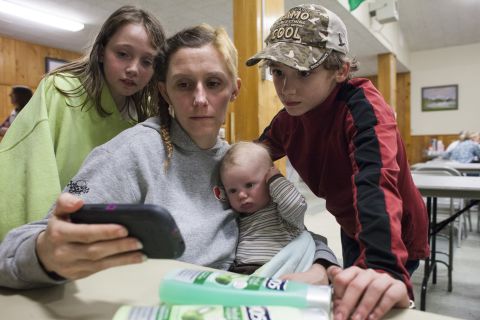The Langston family watches an online news clip about the landslide on Sunday, March 23, while they stay at a temporary Red Cross shelter in Darrington. The family's home was flooded after the landslide blocked the Stillaguamish River.