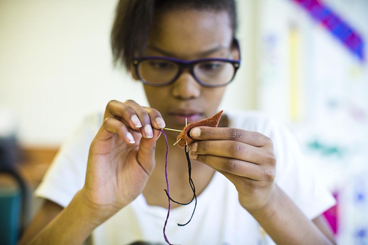 Ananda Gates, 11, sews during art class at Hess Academy. Outside core academics, students also study art, music, dance and yoga.
