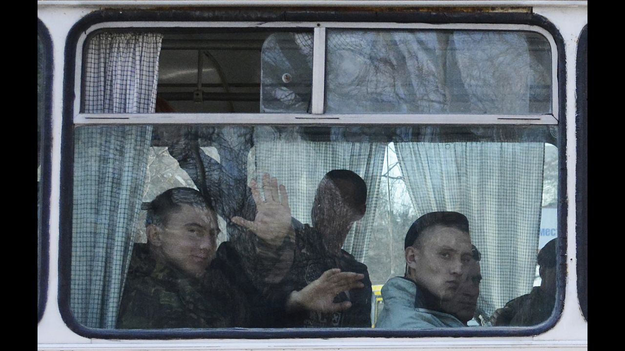 Ukrainian marines wave as they leave a base in Feodosia, Crimea, on Tuesday, March 25. 