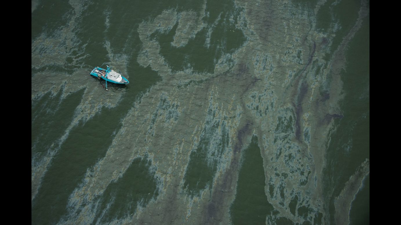 A vessel surrounded by a sheen of oil floats near Galveston on Sunday, March 23.