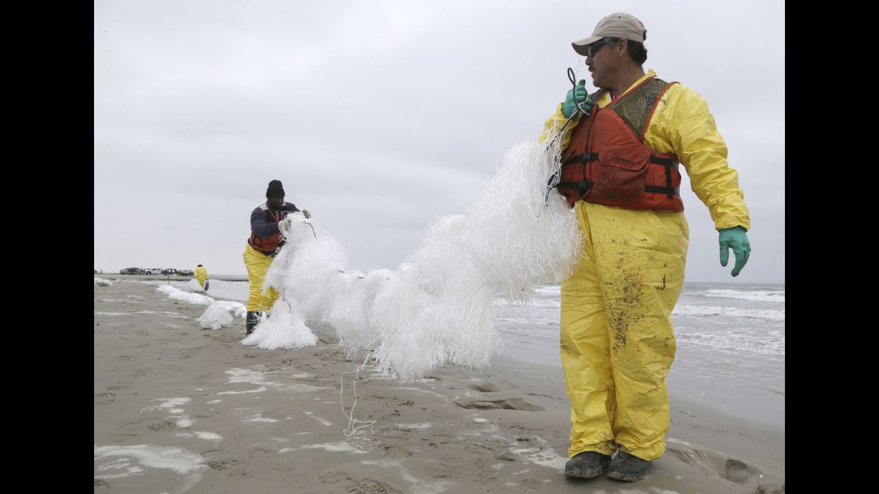 After a weekend boat collision caused 168,000 gallons of oil to spill into the Port of Houston, cleanup workers spread viscous snare line to snag oil Monday, March 24, along East Beach in Galveston, Texas.