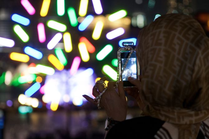 A spectator takes a photo of Big Tree, a light installation by architect Jacques Rival.