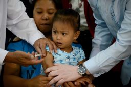 A mother holds her child as she receives a measles vaccine at the Department of Health headquarters in Manila, Philippines, on January 21, 2014.