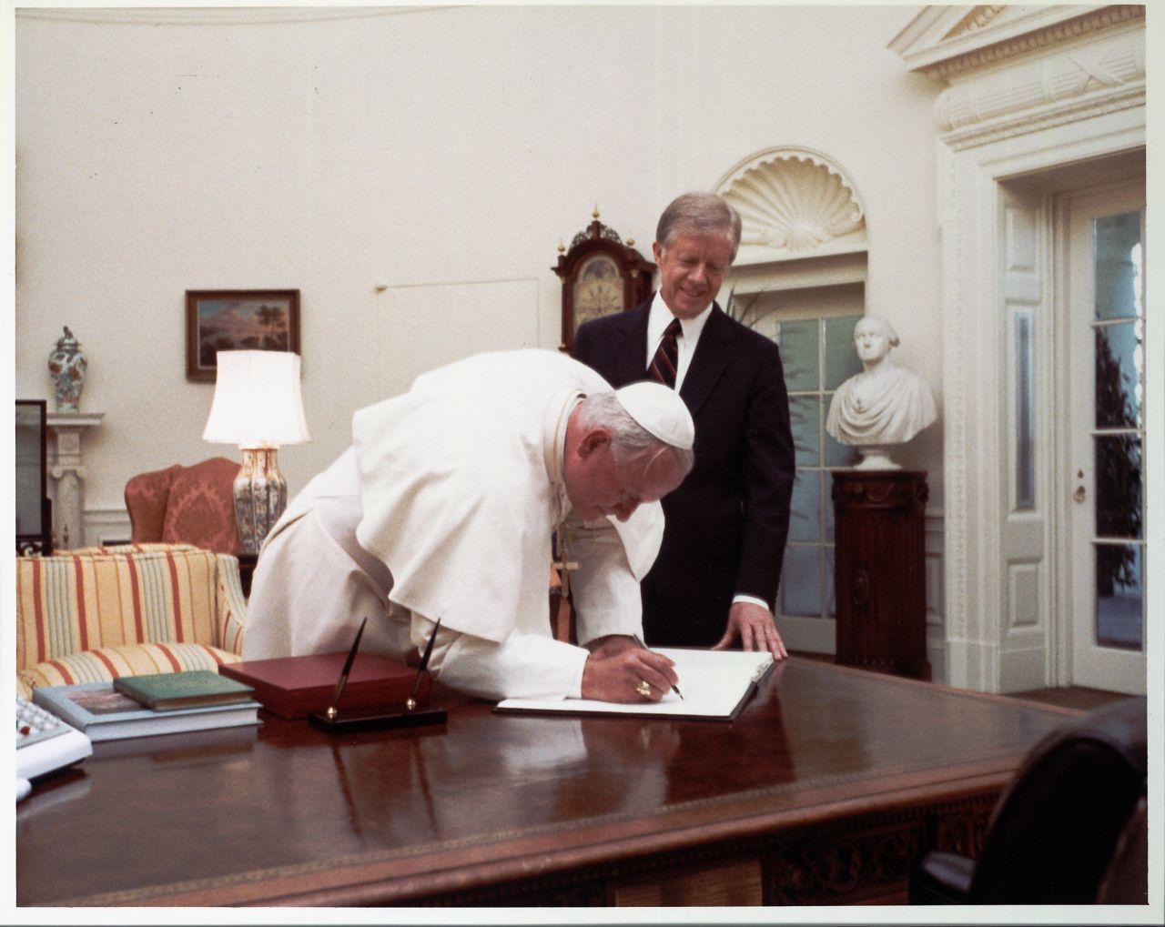 El presidente Jimmy Carter observa al papa Juan Pablo II mientras firma el libro de visitas de la Casa Blanca en 1979. Fue el primer Papa en visitar la residencia oficial del presidente estadounidense.