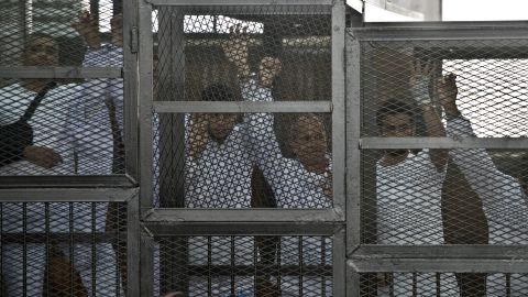 File photo: Australian journalist Peter Greste (C) of Al Jazeera and his colleagues stand inside the defendants cage during their trial for allegedly supporting the Muslim Brotherhood.