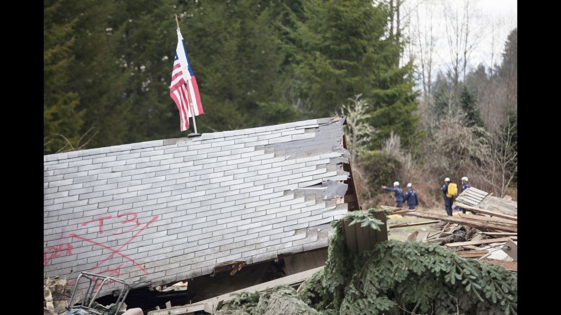 The roof of a house sits among debris as emergency personnel continue to look for survivors on March 25.