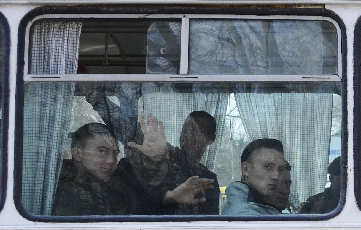 FEODOSIA, CRIMEA: Ukrainian marines leave their base in Crimean Feodosia. Ukrainian soldiers piled onto buses and began their journey to mainland Ukraine, as former comrades saluted them from outside a base overrun by Russian forces in the past few days. 