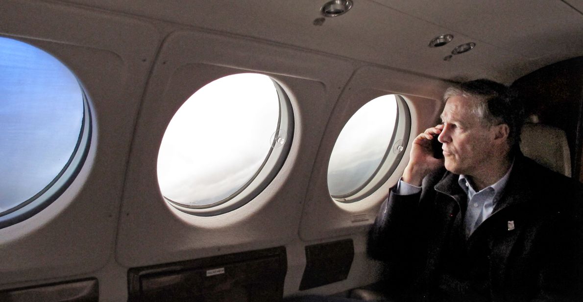 Washington Gov. Jay Inslee speaks on the phone with a victim's family member as he flies to the Snohomish County Emergency Operations Center in Everett on March 26.