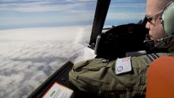 Flight Lieutenant Jayson Nichols looks out of the cockpit of a Royal Australian Air Force AP-3C Orion aircraft over cloud while searching for the missing Malaysian Airlines flight MH370 over the southern Indian Ocean on March 27, 2014.  Thunderstorms and gale-force winds grounded the international air search for wreckage from Flight MH370, frustrating the effort yet again as Thailand reported a satellite sighting of hundreds of floating objects.    AFP PHOTO / POOL        (Photo credit should read Michael Martina/AFP/Getty Images)