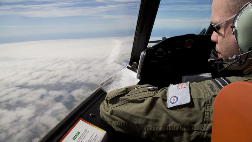 Flight Lieutenant Jayson Nichols looks out of the cockpit of a Royal Australian Air Force AP-3C Orion aircraft over cloud while searching for the missing Malaysian Airlines flight MH370 over the southern Indian Ocean on March 27, 2014.  Thunderstorms and gale-force winds grounded the international air search for wreckage from Flight MH370, frustrating the effort yet again as Thailand reported a satellite sighting of hundreds of floating objects.    AFP PHOTO / POOL        (Photo credit should read Michael Martina/AFP/Getty Images)