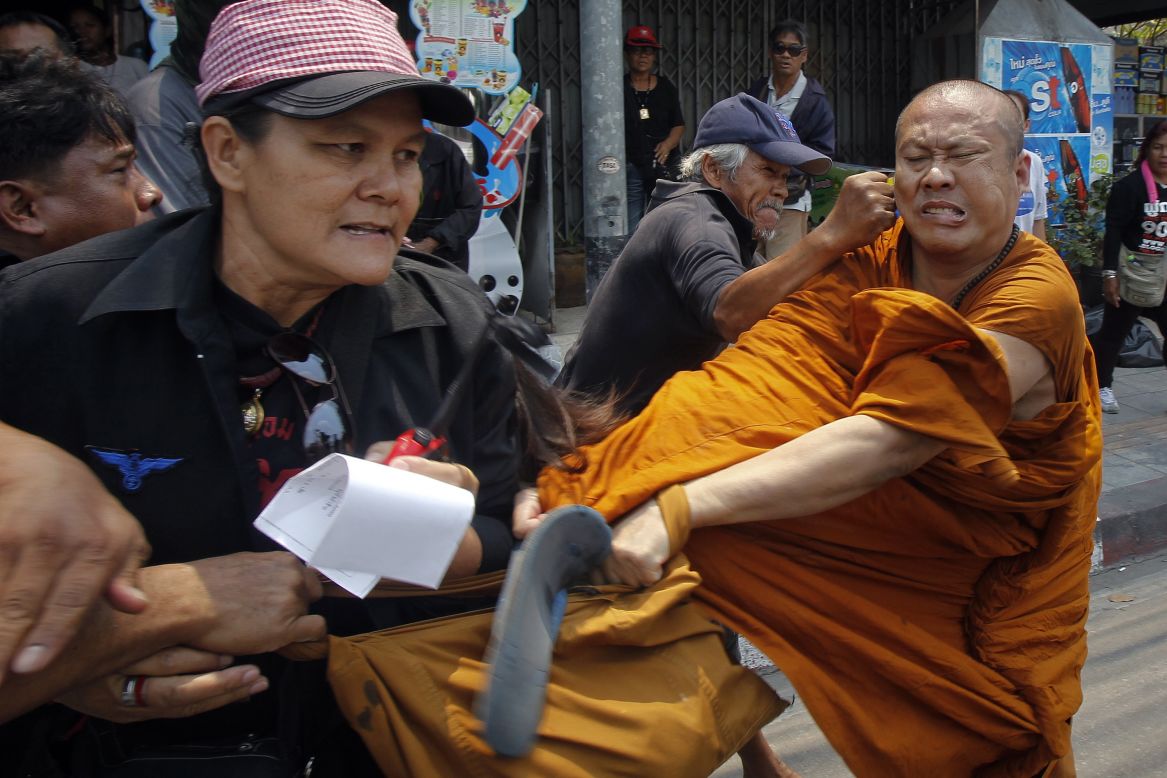 Members of the pro-government "red shirt" movement attack a Buddhist monk on the outskirts of Bangkok, Thailand, on Monday, March 24. The monk was attacked after he shouted complaints to group members blocking a road near the office of the National Anti-Corruption Commission.