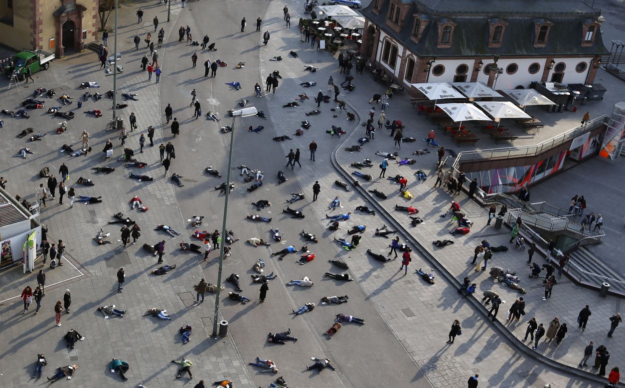 People lie down in Frankfurt, Germany, on Monday, March 24, as part of an art project to remember the 528 victims of the Katzbach concentration camp.