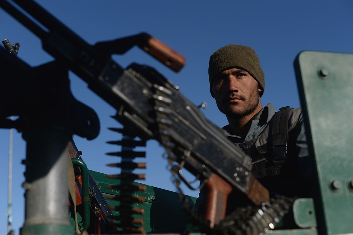 An Afghan policeman is seen behind a machine gun Tuesday, March 25, after <a href="http://www.cnn.com/2014/03/25/world/asia/afghanistan-violence/index.html">a deadly attack</a> on an election office in Kabul.