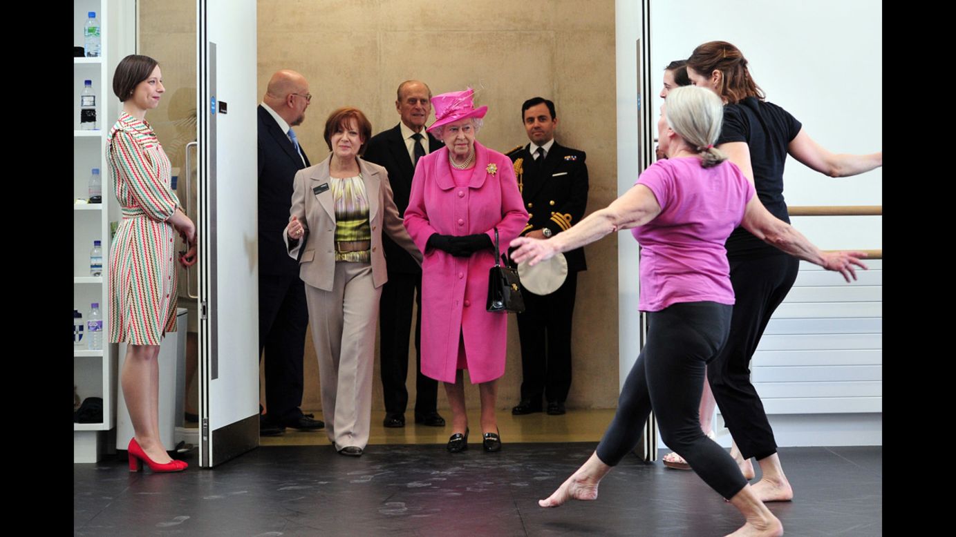 Britain's Queen Elizabeth II, wearing the pink hat, watches dancers perform Friday, March 21, during a visit to the Rambert Dance Company in London.