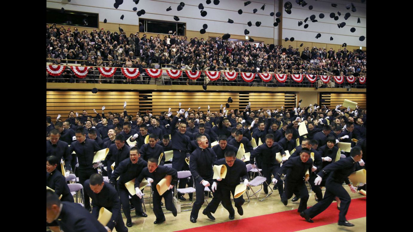 Graduating cadets toss their caps in the air Saturday, March 22, during the commencement ceremony at Japan's National Defense Academy in Yokosuka.