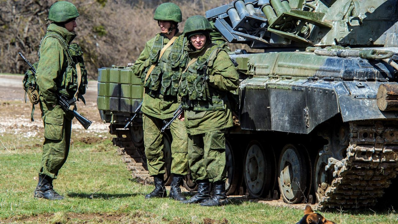 Russian soldiers stand near a tank outside a former Ukrainian military base in Perevalnoye, near the Crimean capital Simferopol, on March 27, 2014.