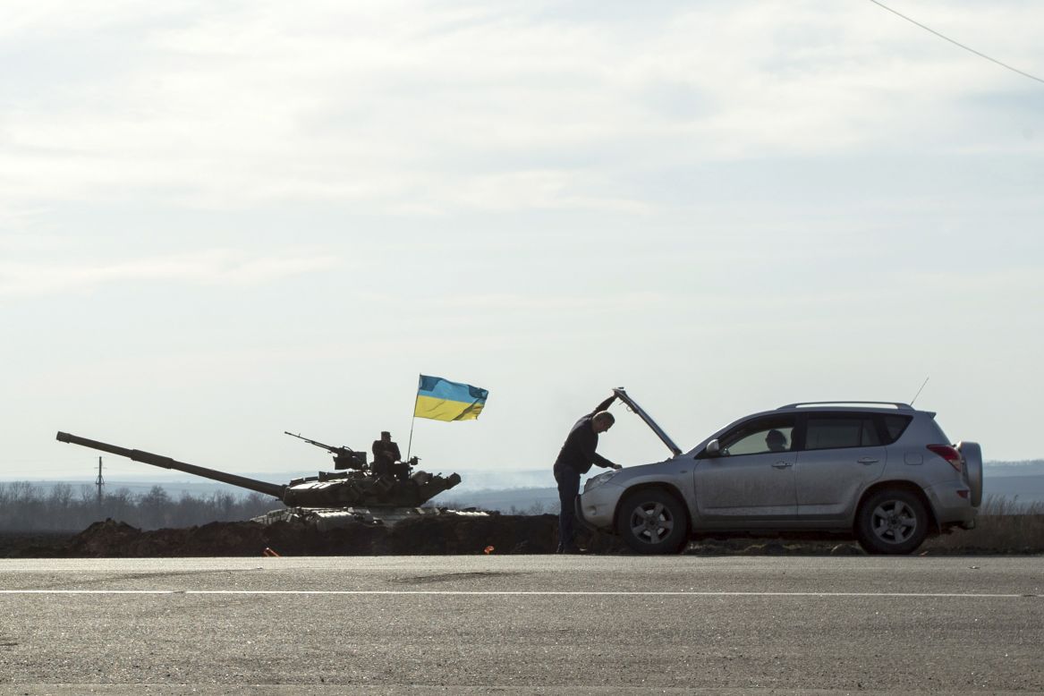 A motorist checks his car next to a tank Monday, March 24, in Kharkiv, Ukraine, close to the Russian border. There have been <a href="http://www.cnn.com/2014/03/26/world/gallery/ukraine-crisis/index.html">heightened tensions in the country</a> since Russia annexed the region of Crimea earlier this month.