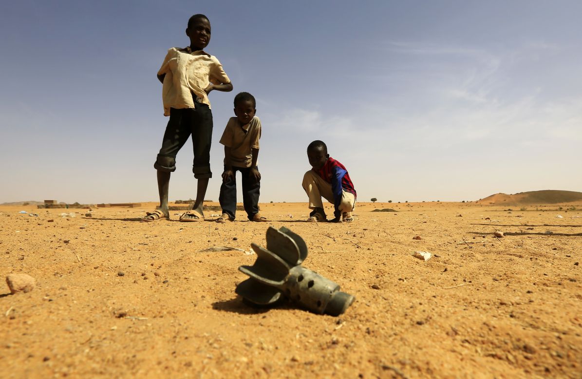 Children look at the fin of a mortar projectile that was found at the Al-Abassi displacement camp on Tuesday, March 25, after an attack by rebels in North Darfur, Sudan.