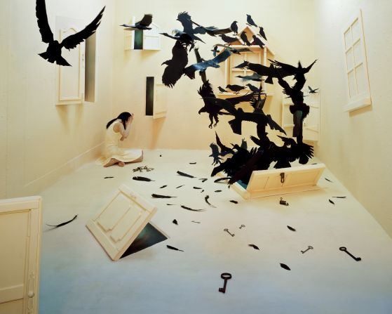 Fears and negative feelings are represented as menacing crows bursting through a door in the floor. "For me large birds are threatening, and the image of their feathers, beak, and curved talons is frightening," says Lee. The doors represent future changes and challenges that the artist will have to go through. 