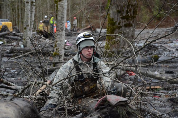 Staff Sgt. Jonathon Hernas of the Air National Guard carefully makes his way across debris and mud while searching for missing people March 29 in Oso.