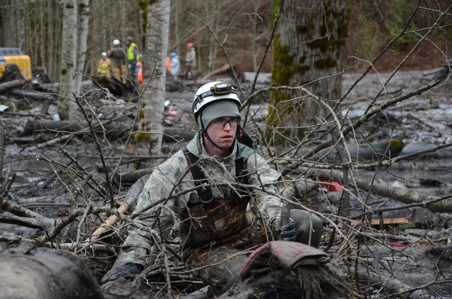 Staff Sgt. Jonathon Hernas of the Air National Guard carefully makes his way across debris and mud while searching for missing people March 29 in Oso.
