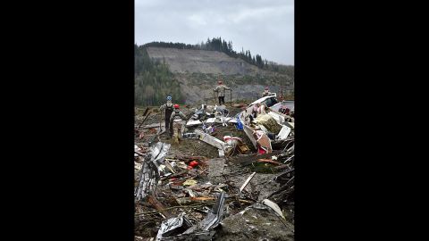 Air National Guard members look out at the hill where the landslide originated while they search through debris March 29 in Oso. 