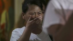 A newly arrived Chinese relative of passengers on board the missing Malaysia Airlines flight MH370 breaks into tears as they spoke to reporters at a hotel in Subang Jaya, Malaysia, Sunday March 30, 2014. Several dozen Chinese relatives of passengers on Flight 370 arrived in Malaysia Sunday to demand more information about what happened to the airliner that has been missing for more than three weeks, saying there has not been enough information on what happened to their loved ones. Her T-shirt reads: "Praying that MH370 returns home safely." (AP Photo/Aaron Favila)